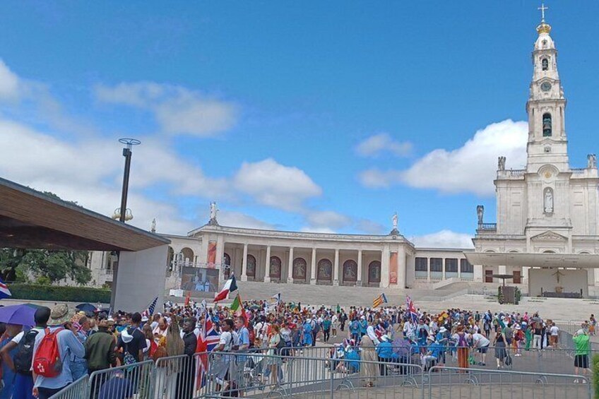 A large crowd gathered in front of a historic building with a prominent clock tower. 3