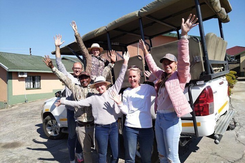 A group of people standing in front of a vehicle with raised hands. 3