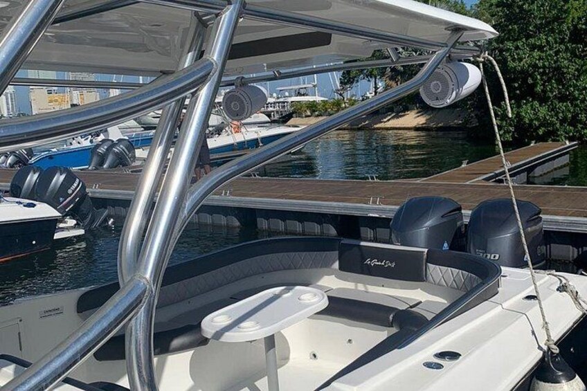 Ein Boot liegt in einer Marina festgemacht, mit einem Holzboden, einer weißen Kabine und zwei Außenbordmotoren. 4