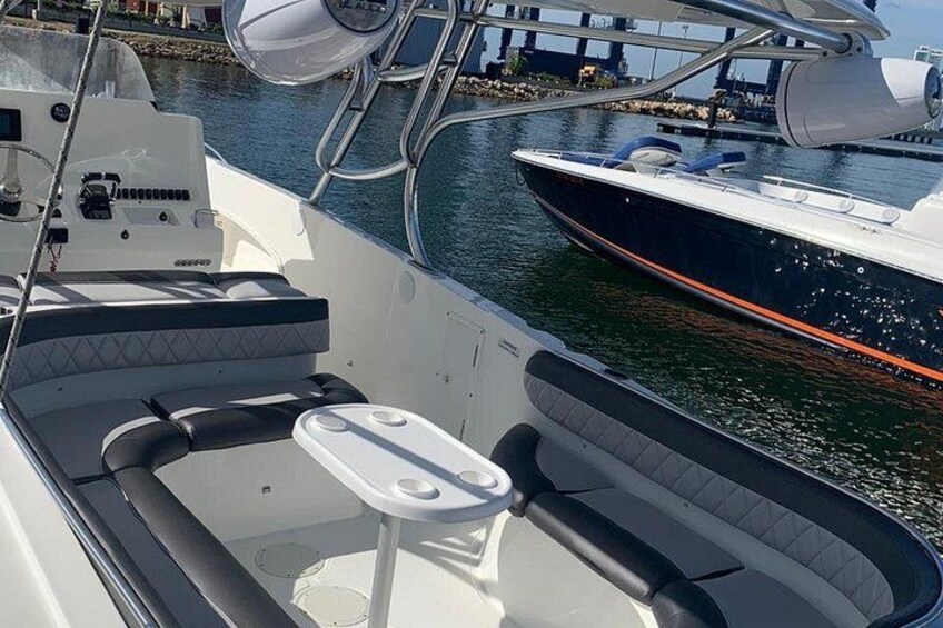 Schiffsinnenraum mit Tisch und Sitzgelegenheiten, vertäut in der Nähe anderer Boote. 5