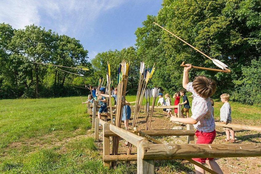 A group of people practicing archery outdoors. 3