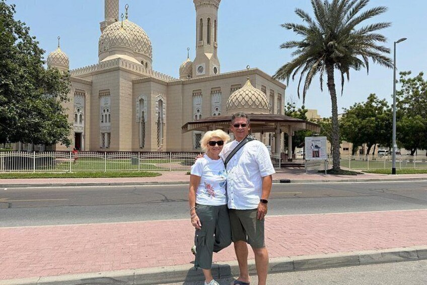 A large, ornate building with domes and minarets, a paved walkway, and a palm tree. 3