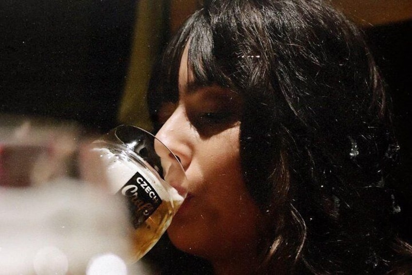 A person drinking from a glass with a label. 5