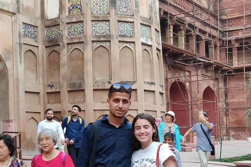 A group of people in front of a historic building with intricate tile work and arches. 3