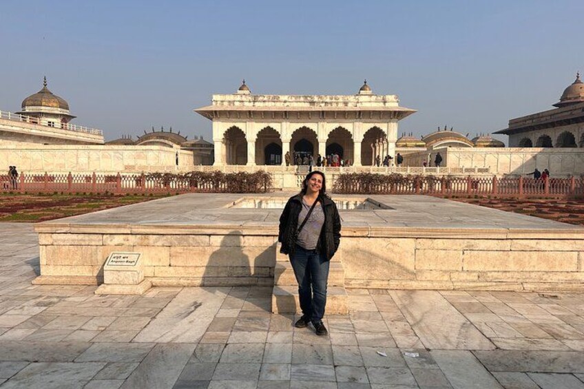 A person standing in front of a large, historic building with domes and arches. 5