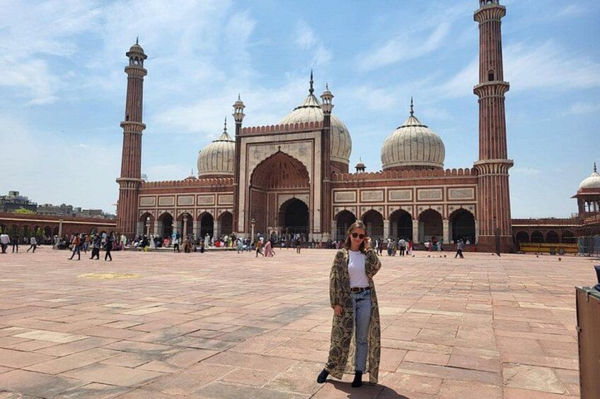 Una gran mezquita con numerosas cúpulas y minaretes, un amplio patio y gente caminando. 3