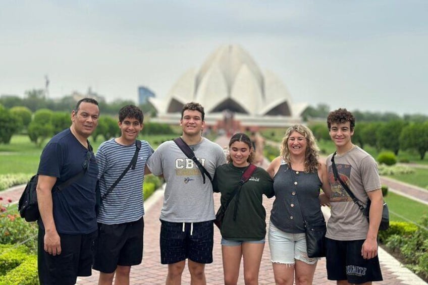 Un grupo de personas frente a una gran estructura arquitectónica moderna y blanca. 1