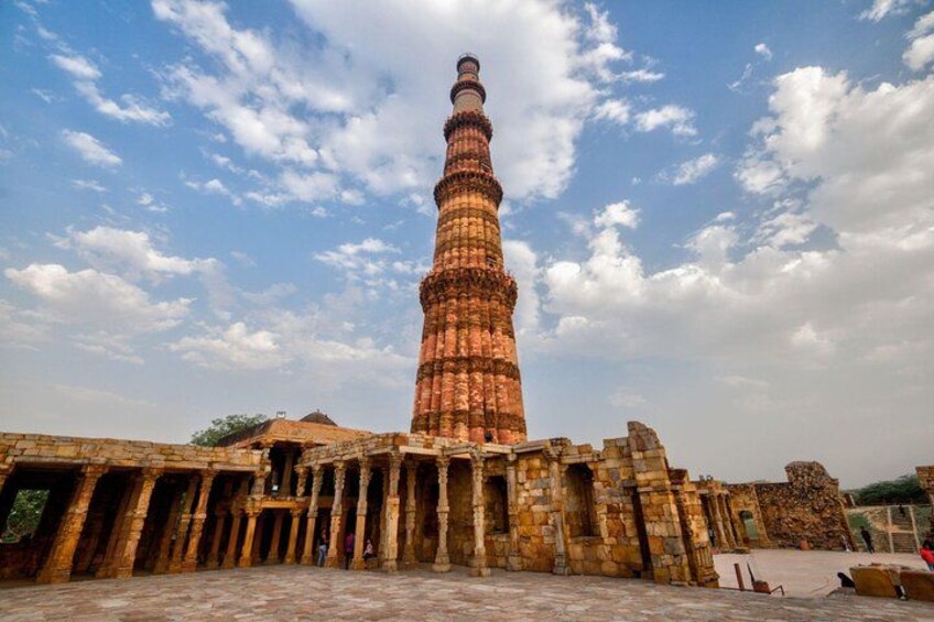 Un'antica torre con un minareto a spirale, circondata da rovine storiche. 5