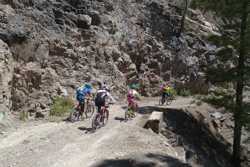 A group of cyclists on a rocky mountain trail. 5