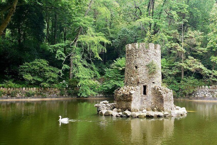 A stone tower surrounded by water and greenery. 3