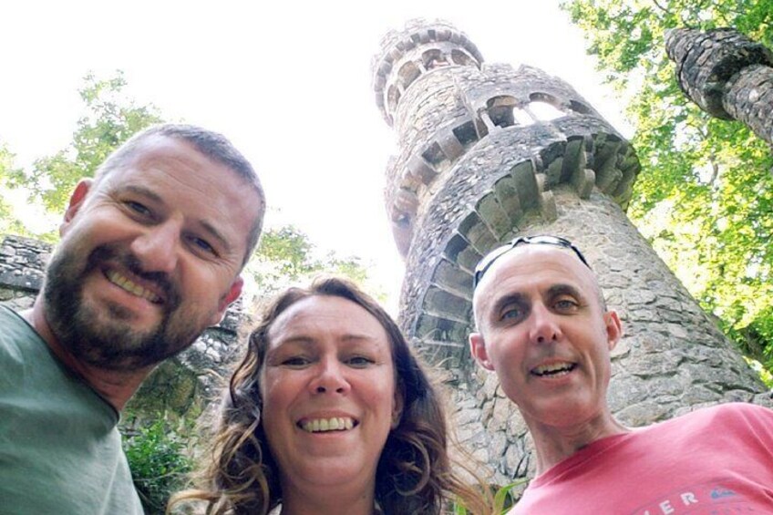 Three people standing in front of a stone tower with a spiral staircase. 2