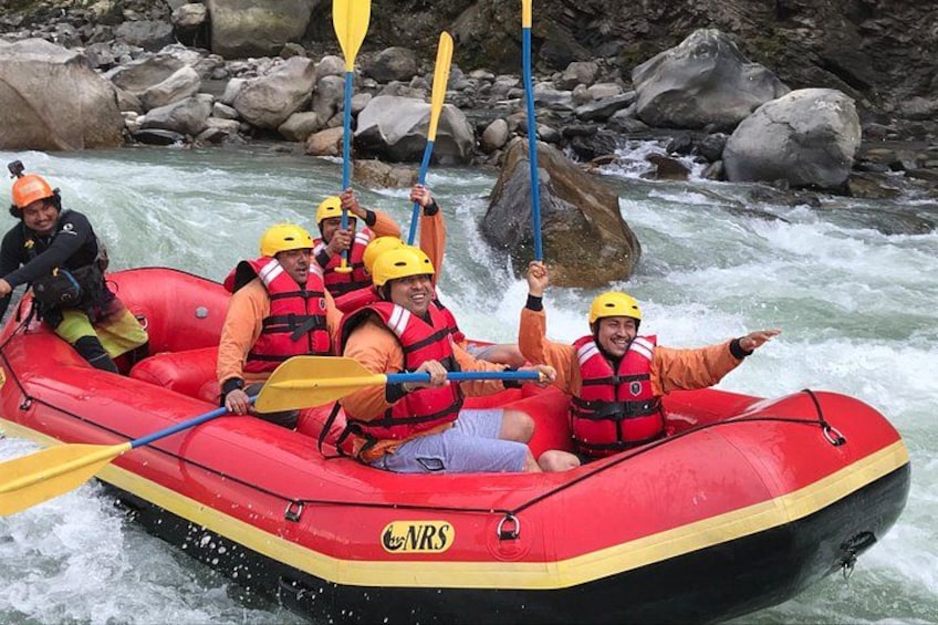 Un gruppo di persone su un gommone rosso in un fiume, con caschi e giubbotti di salvataggio. 1