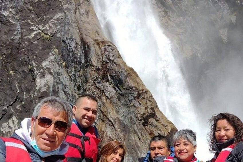 Eine Gruppe von Menschen steht vor einem großen Wasserfall. 1