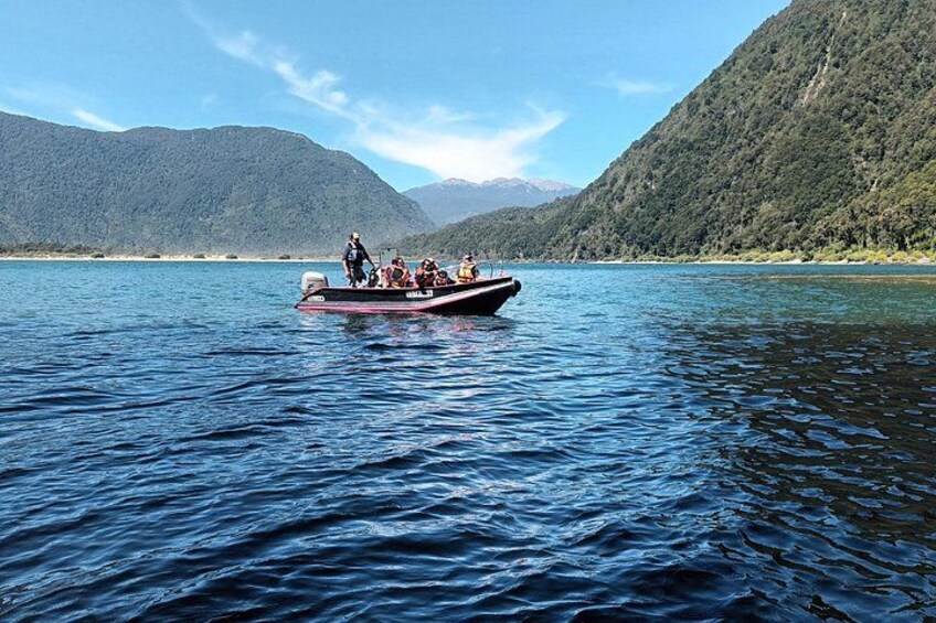Ein Boot auf einem ruhigen See vor einer Bergkulisse. 4