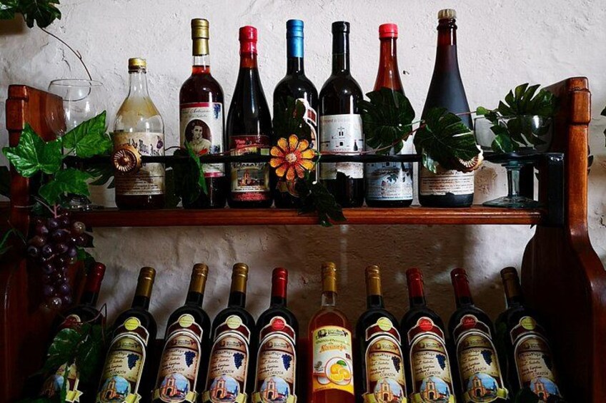 Une collection de bouteilles de vin, disposées sur des étagères, certaines avec leurs étiquettes et d’autres avec leurs bouchons. 2