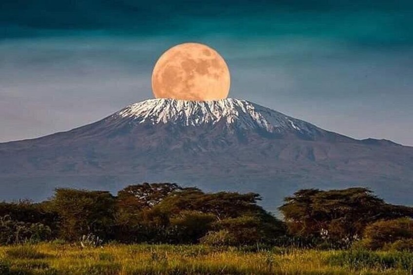 Una montaña con una luna grande al frente. 1