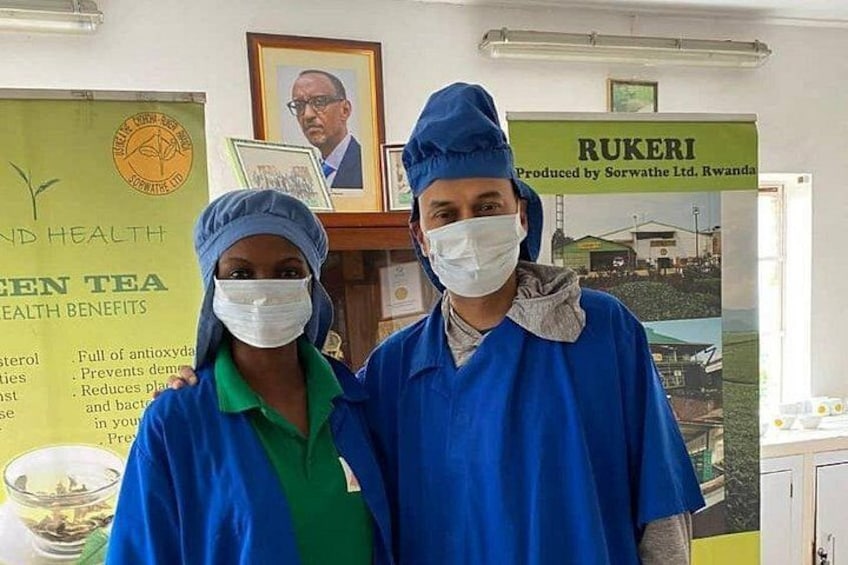 Due persone in divisa blu e cuffia chirurgica in una stanza con un poster sui benefici per la salute del tè verde e un quadro appeso al muro. 5