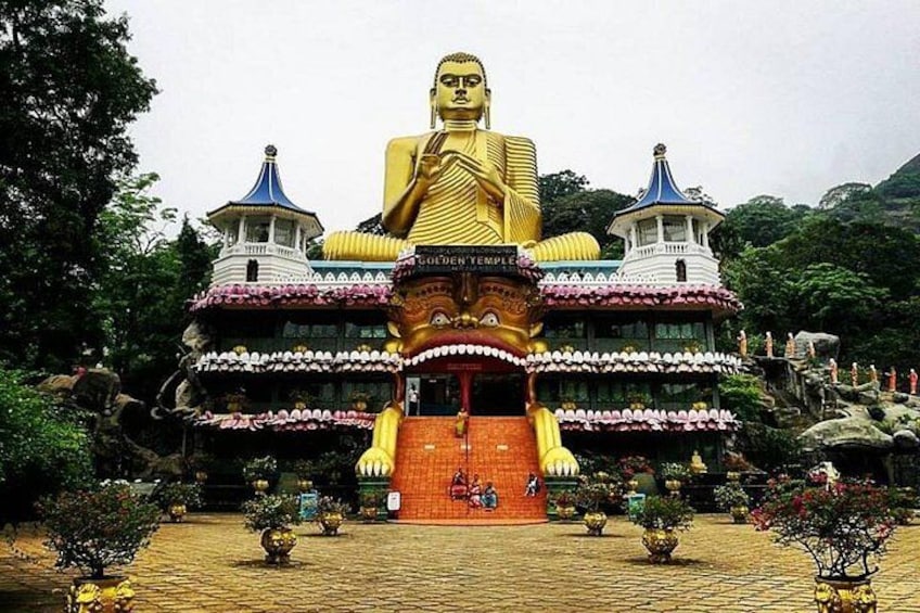 Une grande statue de Bouddha en or se dresse devant un temple à l’architecture aux couleurs vives. 5