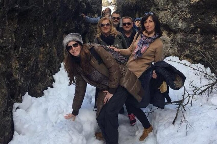 Un grupo de personas en un entorno nevado al aire libre, con terreno rocoso y suelo cubierto de nieve. 4