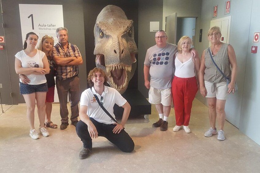 Een groep mensen staat voor een dinosaurusexpositie. 2