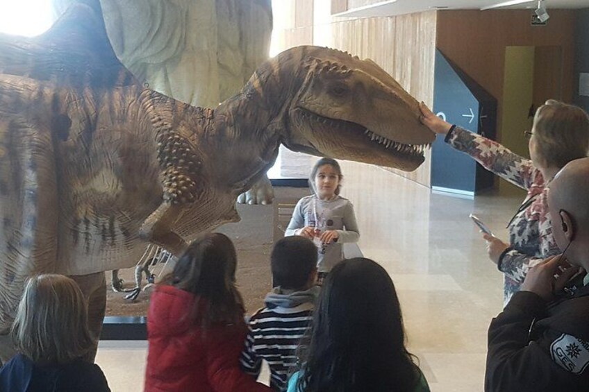 Een groot skelet van een dinosaurus, bekeken door een menigte mensen. 5