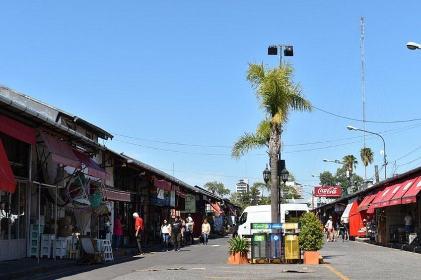 A street with shops, a palm tree, and a Coca-Cola sign. 5