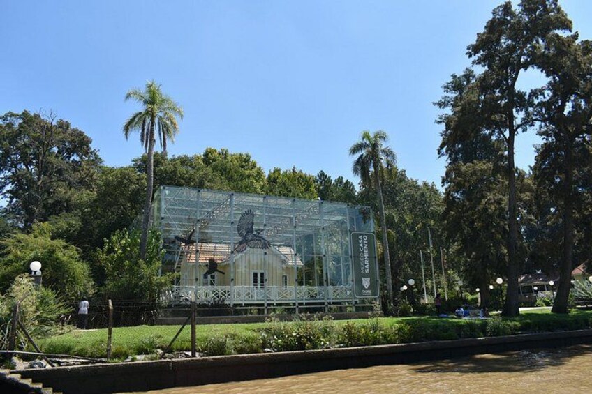 A large outdoor billboard with a historical scene, surrounded by trees and a clear sky. 4