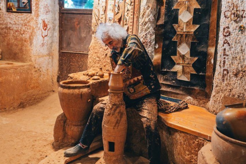 An elderly person working with pottery in a rustic workshop. 3