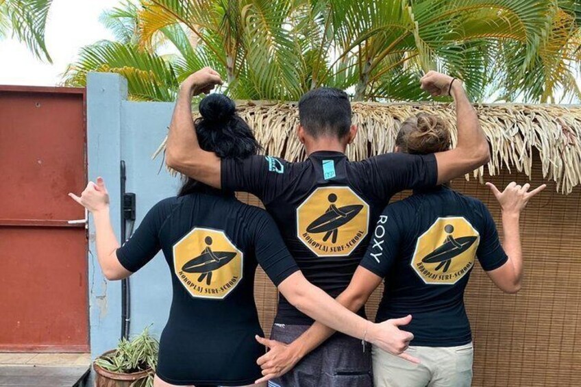 Drei Personen mit übereinstimmenden schwarzen T-Shirts, verziert mit einem Surfbrett-Logo und dem Schriftzug 'ROXY' auf der Rückseite. 5
