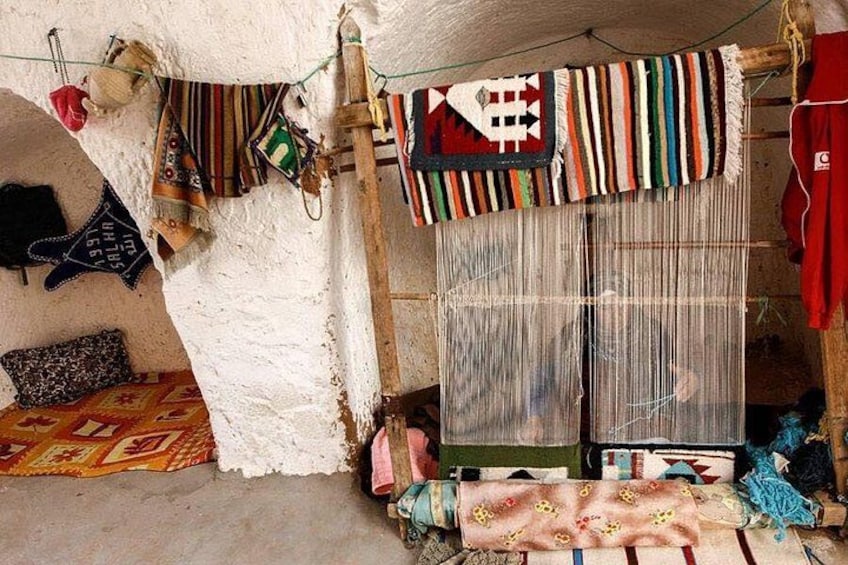 A traditional weaving loom with colorful textiles and patterns. 4