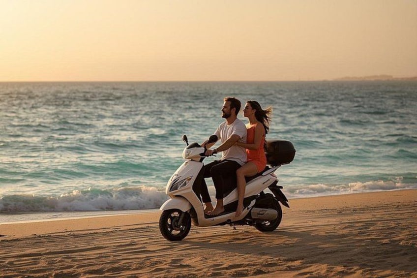 Un couple sur un scooter, sur une plage, avec l’océan en arrière-plan. 5