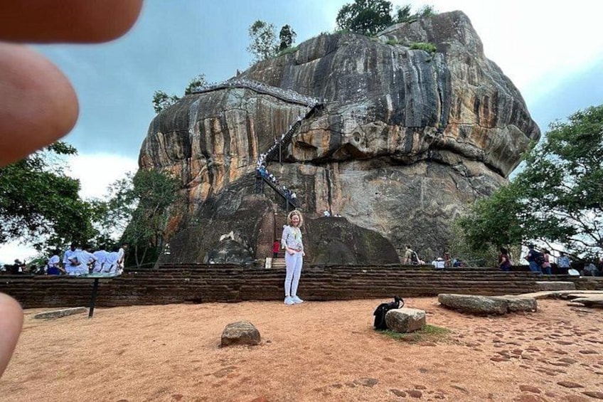 A large rock formation with a person standing in front of it. 2