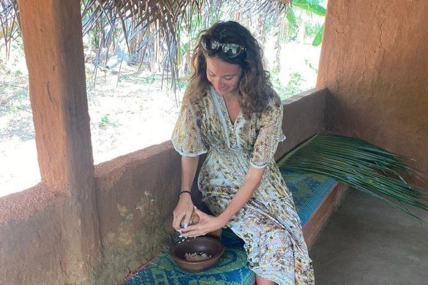A person sitting on a bench, grinding something in a bowl. 4