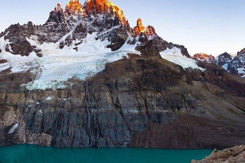 Una montaña con un glaciar y un lago turquesa. 5