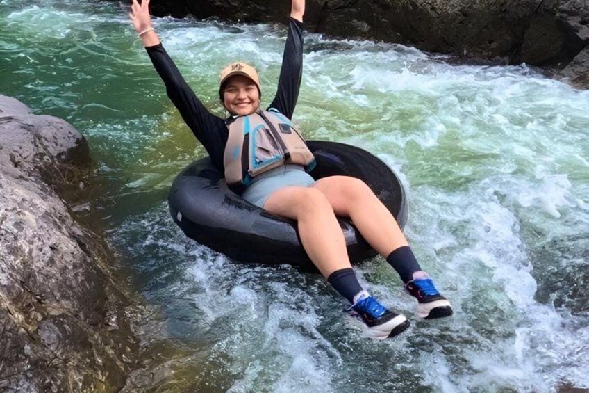 A person floating on a raft in a river with rocks and rapids. 4