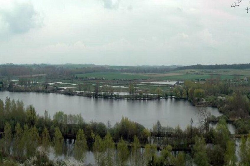 A large body of water surrounded by trees and fields. 3