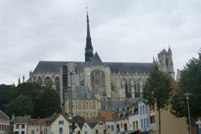 Una gran catedral gótica con una aguja alta, rodeada de edificios de colores. 3