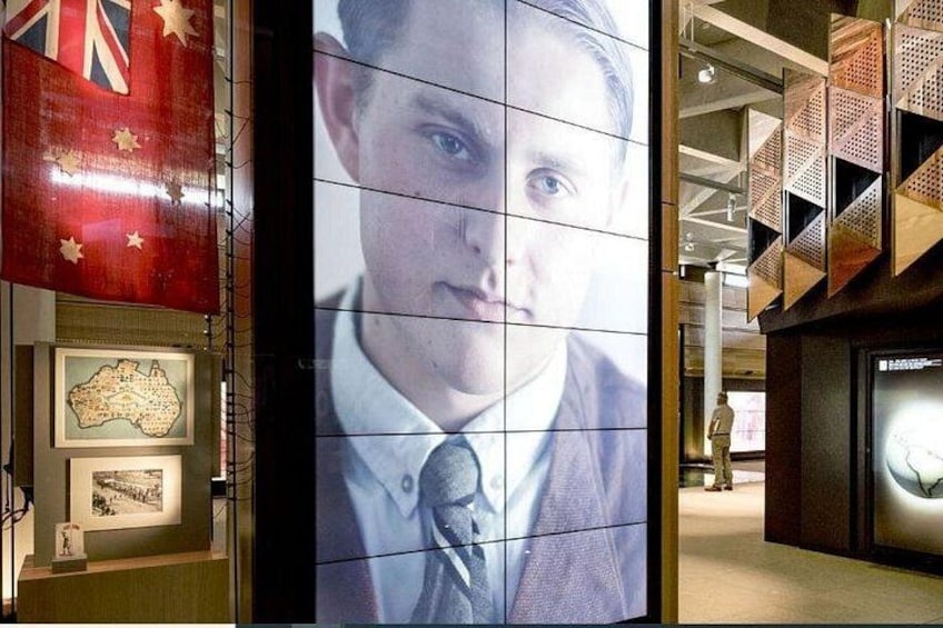 A wall with a large portrait, a map, and a flag. 3