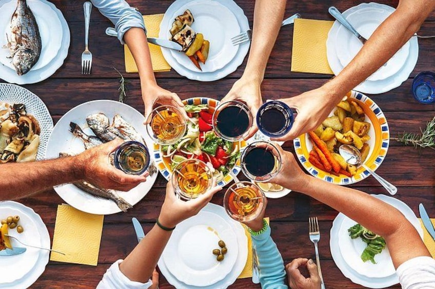 A group of people around a table with various dishes and drinks. 2