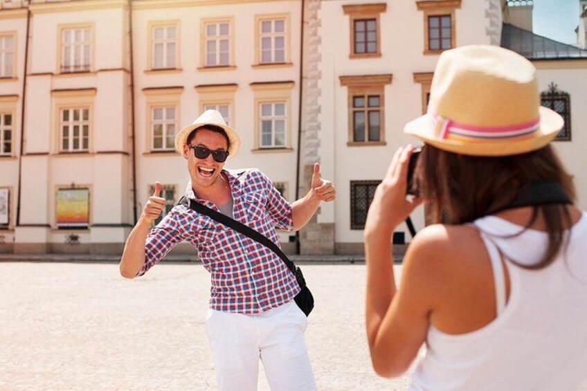 A person in a plaid shirt and white pants giving a thumbs-up gesture. 4