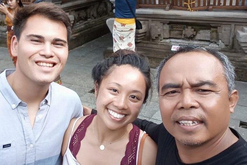 Drei Personen posieren für ein Foto vor einem Tempel mit Steinschnitzereien. 3