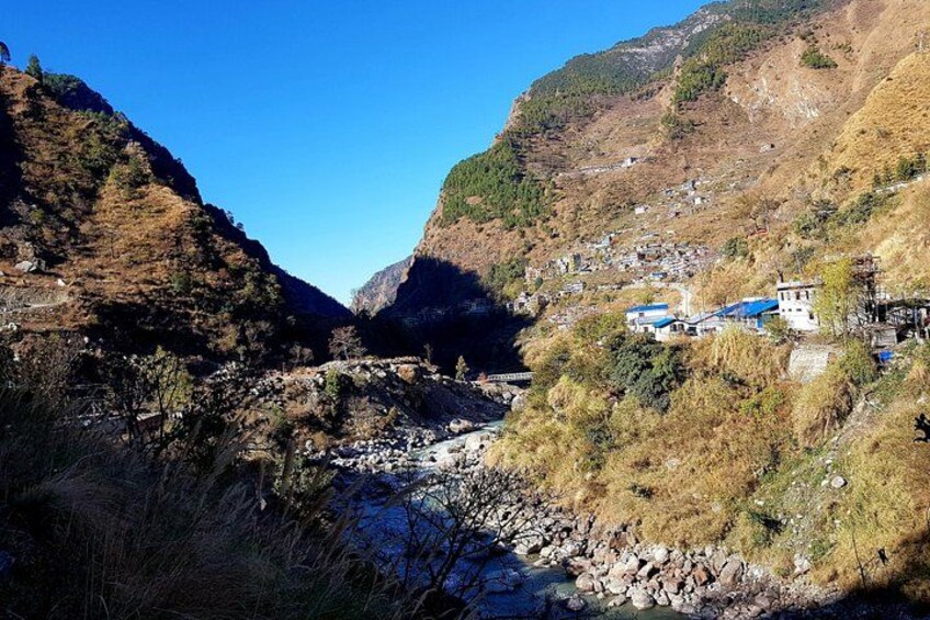 A river flowing through a valley with houses on the hillside. 2