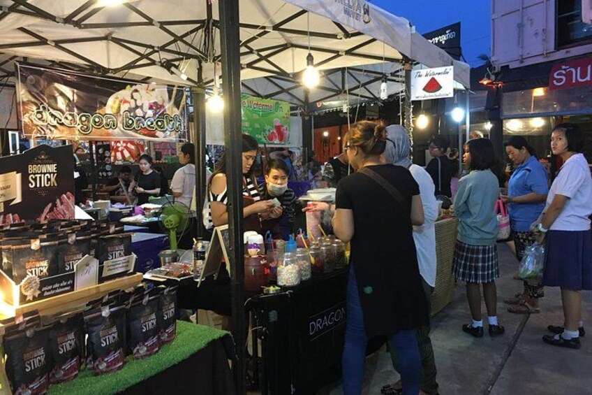 Un chiosco di cibo di strada con un cartello che riporta 'Dragon Breath' e una persona che prepara del cibo. 5