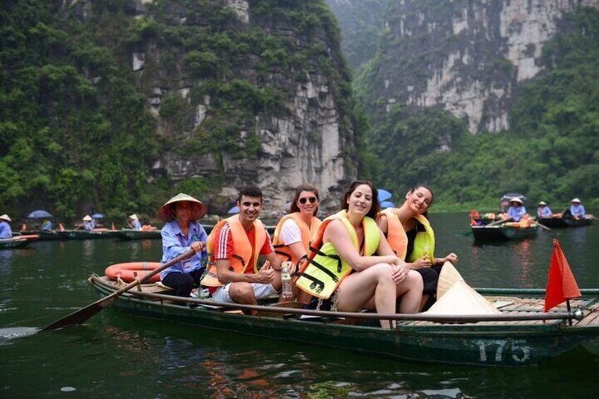 Un grupo de personas en una barca en un río, con acantilados al fondo. 3