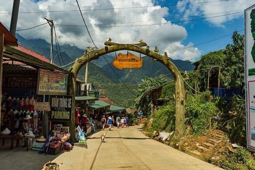 A street with shops, a signboard, and a mountain in the background. 3