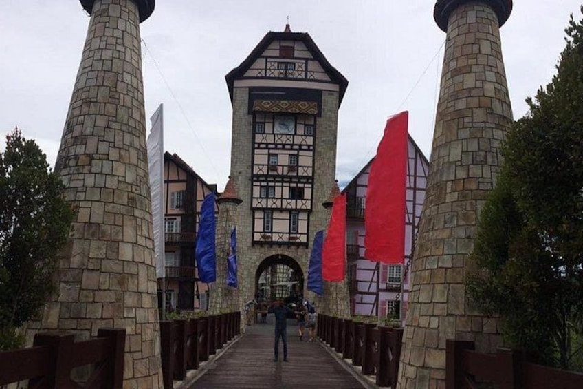 A stone bridge leading to a traditional building with a tower. 1