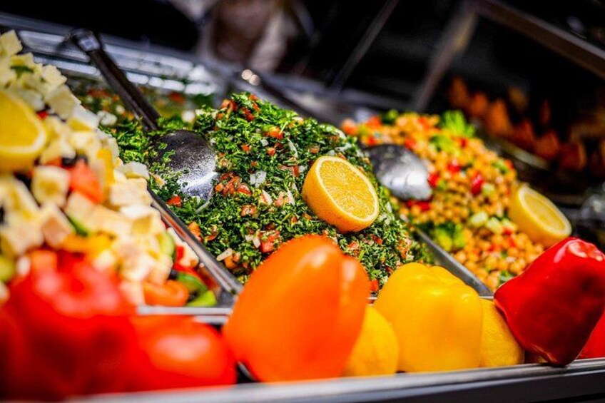 A buffet with various dishes, including salads and vegetables. 1