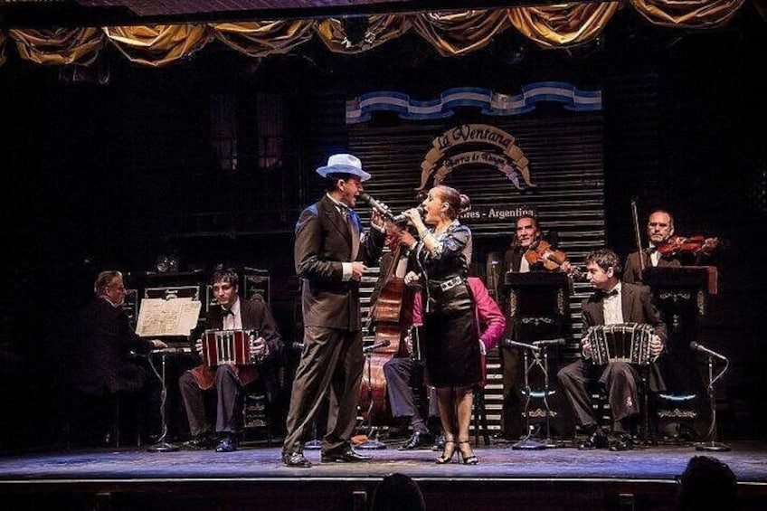 A stage with a band performing, including a singer and musicians with instruments. 3