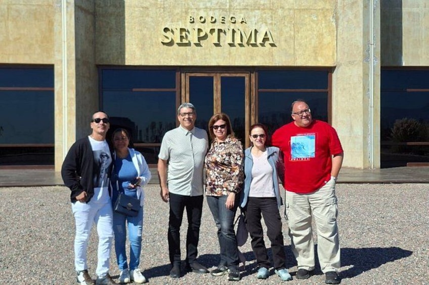 A group of people standing in front of a building with the sign 'BODEGA SEPTIMA'. 3