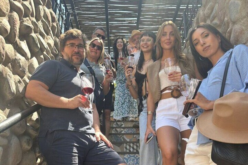 Un groupe de personnes se tient à l’extérieur, chacune tenant un verre de vin. 2